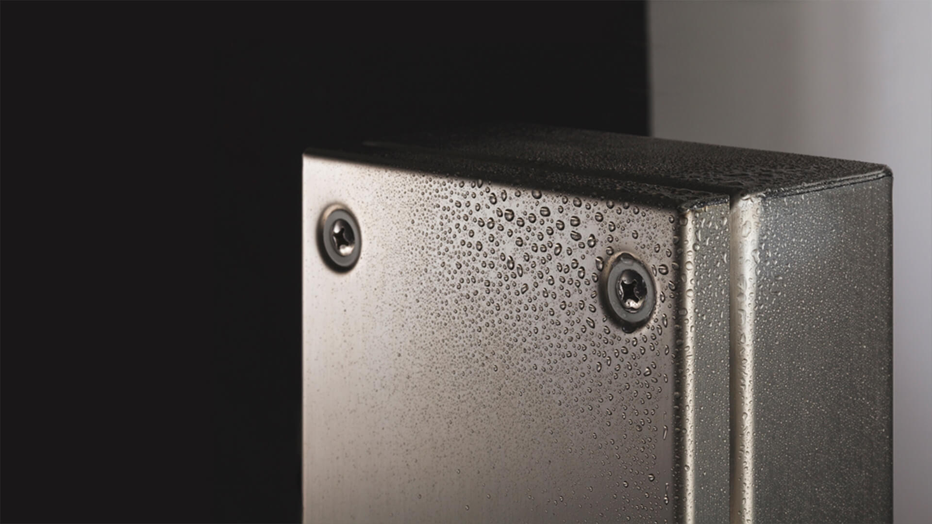 Stainless steel enclosure door with water beading on the surface